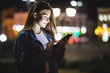 © F8  \ Suport Ukraine - Beautiful young woman using tablet in the city at night bokeh