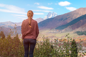 beautiful blonde girl on the background of Mount Ushba, mountains of Svaneti, Georgia