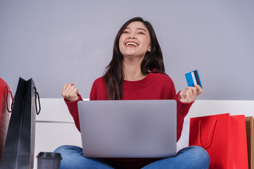 Sticker - cheerful woman using laptop computer to shopping online on bed