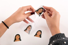 Woman Placing A Set Of Passport Photos In Plastic