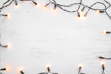 Wall Mural - christmas lights bulb frame decoration on white wood. merry christmas and new year holiday backgroun