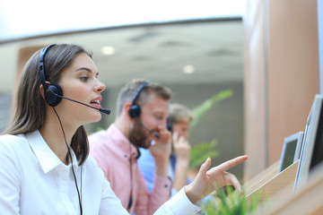 Attractive positive young businesspeople and colleagues in a call center office.