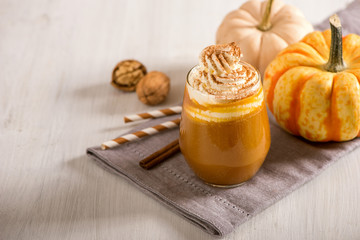 Pumpkin spice latte, hot coffee drink with pumpkins, whipped cream and spices