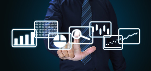 Fototapete - Businessman and big data analytics and business intelligence concept with chart and graph icons on a digital screen interface
