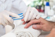 Kosmetyczka w białych rękawiczkach jednorazowych w salonie kosmetycznym podczas zabiegu manicure piłuje paznokcie pilnikiem kosmetycznym u dłoni mężczyzny