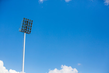 Spotlight tower at sport stadium with blue sky and cloud background, Copy space