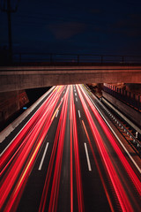 Wall Mural - White light trails from cars on a traffic motorway at night view. Abstract motion blur movement