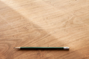 Wall Mural - Pencil on a rustic wooden desk, in natural window lighting. Shallow depth of field. Focus is on the forehand pencil.