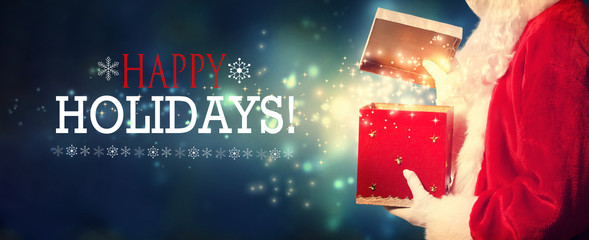 Wall Mural - Happy holidays message with Santa opening a gift box on a shiny light background