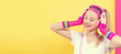 Woman in 1980's fashion with headphones on a split yellow and pink background