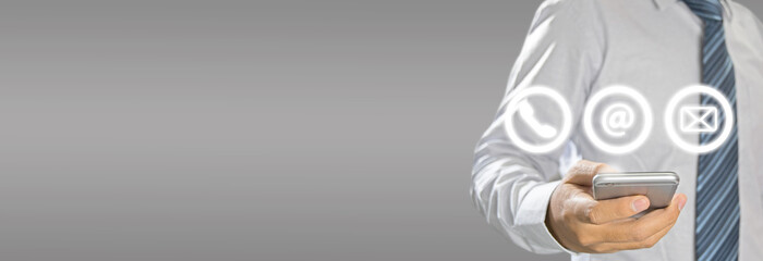 Poster - Hand of Businessman holding mobile smartphone with ( telephone, email, mail ) icon. CONTACT US Concept.
