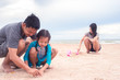 © arrowsmith2 - Father and daughter are making sand piles on the beach.Happy family concept
