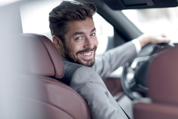 Successful man sitting behind the wheel of a prestigious car