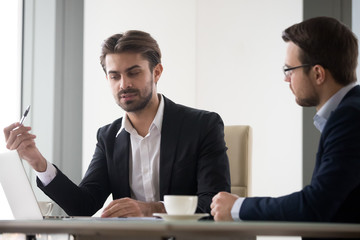 two caucasian men in suits are discussing and planning project. coworkers or manager and subordinate