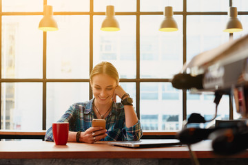 Young russian freelance use smartphone with laptop in coffee shop