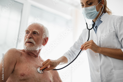 Fotografía Low angle portrait of shirtless old gentleman looking away with serious expressi