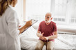 © Yakobchuk Olena - Portrait of male patient with walking stick talking about his state of health while female physician listening and noting. Focus on bearded gentleman