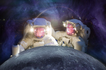 Wall Mural - two huge astronauts observe the moon against the background of the galaxy. elements of this image fu