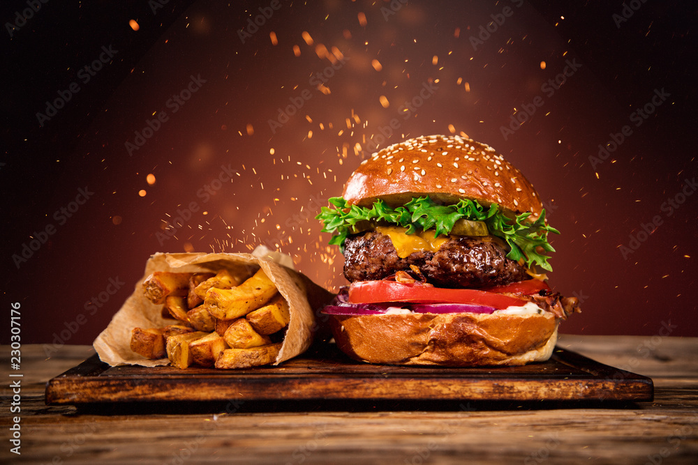 Tasty burger with french fries and fire. - obrazy, fototapety, plakaty 