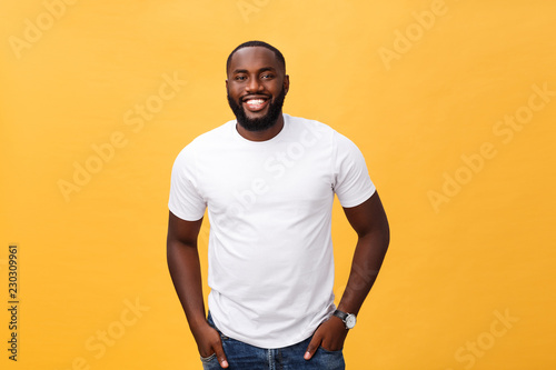 Fotografía Portrait of delighted African American male with positive smile, white perfect teeth, looks happily at camera, being successful enterpreneur, wears white t shirt