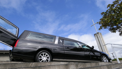 Shot of hearse arriving or leaving a funeral