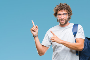 Sticker - Handsome hispanic student man wearing backpack and glasses over isolated background smiling and looking at the camera pointing with two hands and fingers to the side.