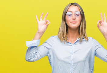 Poster - Young beautiful woman wearing sunglasses over isolated background relax and smiling with eyes closed doing meditation gesture with fingers. Yoga concept.