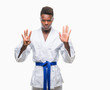 © Krakenimages.com - Young african american man over isolated background wearing kimono showing and pointing up with fingers number nine while smiling confident and happy.