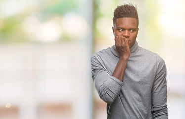 Wall Mural - Young african american man over isolated background looking stressed and nervous with hands on mouth biting nails. Anxiety problem.