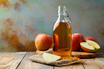 Wall Mural - Apple vinegar. Bottle of apple organic vinegar or cider on wooden background. Healthy organic food. With copy space