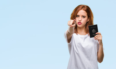 Wall Mural - Young beautiful woman holding passport of united states of america over isolated background pointing with finger to the camera and to you, hand sign, positive and confident gesture from the front