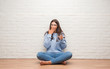 © Krakenimages.com - Young brunette woman sitting on the floor drinking glass of water cover mouth with hand shocked with shame for mistake, expression of fear, scared in silence, secret concept