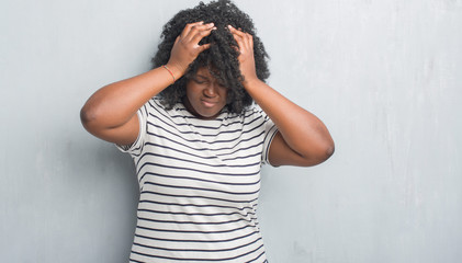 Sticker - Young african american plus size woman over grey grunge wall suffering from headache desperate and stressed because pain and migraine. Hands on head.