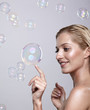 © Serg Zastavkin - Beautiful young blonde woman touches the bubble with her finger