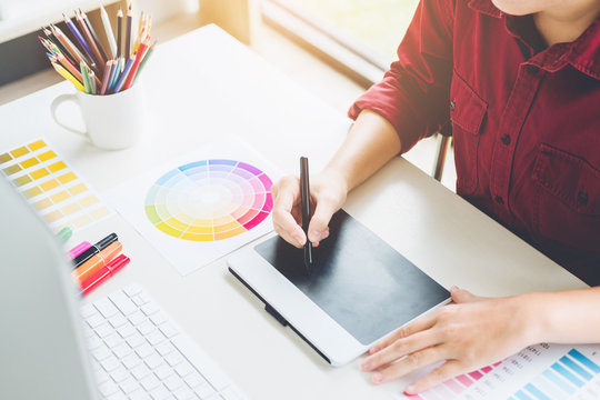 Graphic designer drawing on graphics tablet at workplace