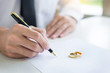 Closeup of a man Signing Contract or premarital agreement, filling petition form agreement of divorce in office at lawyer desk in court room  Conceptual of marriage