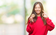© Krakenimages.com - Young asian woman eating chocolate chip cookie over isolated background doing ok sign with fingers, excellent symbol