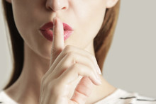 Finger On Lips - Silent Gesture, Woman Holding Her Finger To Her Lips In A Gesture For Silence.