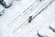 Elevated View Of People Walking During Snow On Frozen Street With Covered Parked Cars