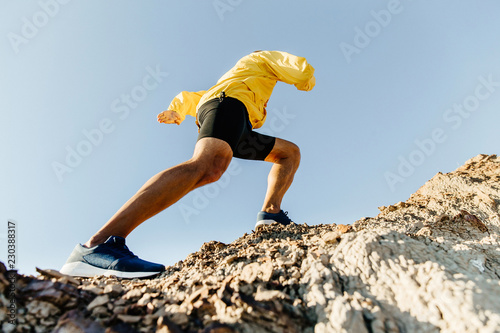 Fotomural male athlete climbs up a steep mountain