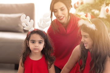 Wall Mural - Christmas and New Year. Mother and daughter at home laughing playful at little girl close-up blurry