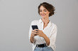 © Drobot Dean - Happy young business woman posing using mobile phone chatting.