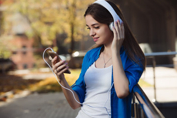 Young woman listening to music with headphones in urban city