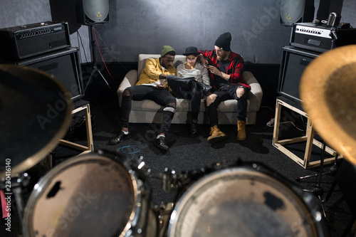 Fotografía Full length portrait of three contemporary young people sitting on couch and chi