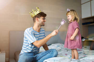 Father casting spell on daughter with magic wand
