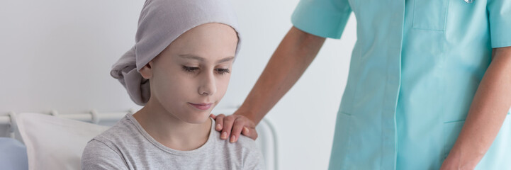 Wall Mural - Panorama of nurse helping sick kid with cancer wearing pink headscarf