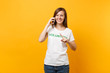 © ViDi Studio - Young woman portrait in white t-shirt with written inscription green title volunteer talking on mobile phone isolated on yellow background. Voluntary free assistance help, charity grace work concept.