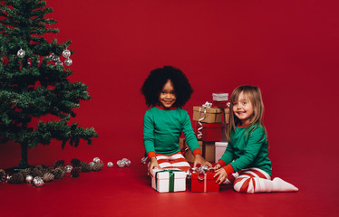 Kids sitting with their christmas gifts