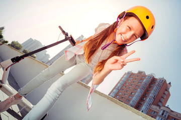 Turn on imagination. Positive delighted girl keeping smile on face while standing near her transport