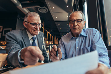 Senior business men discussing at financial report